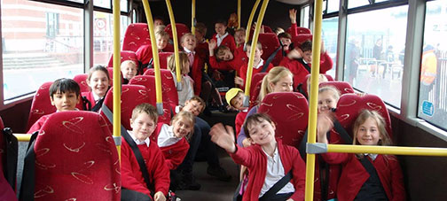 Coach trip of smiling school children in uniform on their way to the Isle of Wight